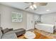Bright bedroom featuring light gray walls, wood floors, a ceiling fan and large windows at 701 N Vermont Ave, Lakeland, FL 33801
