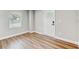 Bright living room featuring wood laminate flooring, neutral paint, a front door, and natural light at 701 N Vermont Ave, Lakeland, FL 33801