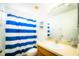 Bright bathroom featuring a blue striped shower curtain and a vanity with a sink at 1142 Mariner Cay Dr, Haines City, FL 33844