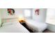 Clean bedroom featuring two twin beds, bright decor, and a nightstand with a bedside lamp at 1142 Mariner Cay Dr, Haines City, FL 33844