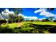Beautiful golf course view with lush green grass, sand traps, and scattered trees under a bright blue sky at 1142 Mariner Cay Dr, Haines City, FL 33844