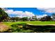 Scenic view of a well-manicured golf course with sand traps, trees, and vibrant green grass at 1142 Mariner Cay Dr, Haines City, FL 33844
