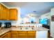 Kitchen featuring wooden cabinets, a stainless steel sink, and a view into the adjacent living area at 1142 Mariner Cay Dr, Haines City, FL 33844