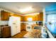 A kitchen featuring wood cabinets, white appliances, and granite countertops, perfect for cooking and entertaining at 1142 Mariner Cay Dr, Haines City, FL 33844