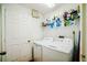 Functional laundry room with a washer, dryer, storage shelves, and a convenient access door at 1142 Mariner Cay Dr, Haines City, FL 33844