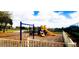 Community playground featuring a slide, swings, and climbing structures, set on wood mulch with a fence surround at 1142 Mariner Cay Dr, Haines City, FL 33844