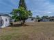 Backyard view showing lawn, trees, white siding, and a view of the neighborhood at 3043 Sego Ln, Lakeland, FL 33801