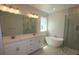 Bright bathroom featuring double vanity, soaking tub, and glass-enclosed shower at 3102 Voyager Ave, St Cloud, FL 34771