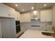 Modern kitchen with white cabinets, stainless appliances, stone countertops and stylish pendant lighting at 3102 Voyager Ave, St Cloud, FL 34771