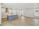 Open living space with kitchen island, wood-look floors, stainless hood vent and recessed lighting at 3102 Voyager Ave, St Cloud, FL 34771