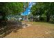 Wide view of backyard with mature trees, a white home, a fenced area, and greenery at 7795 Sw 72Nd Ct, Ocala, FL 34476