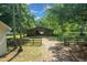 Wooden barn with an open doorway, surrounded by a fence and green trees at 7795 Sw 72Nd Ct, Ocala, FL 34476