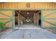 Barn interior featuring an open-air design with green trimmed stalls providing a functional and inviting space for animals at 7795 Sw 72Nd Ct, Ocala, FL 34476