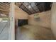 Interior of a barn stall featuring concrete walls, a window, and metal roof beams and ample space at 7795 Sw 72Nd Ct, Ocala, FL 34476