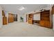 Spacious basement with neutral carpet, built-in wooden cabinets, and ample room for customization at 7795 Sw 72Nd Ct, Ocala, FL 34476