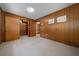 Cozy bedroom with wood-paneled walls, neutral carpet, and a closet with built-in shelving at 7795 Sw 72Nd Ct, Ocala, FL 34476