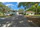 Expansive white two-story home with connecting screened area and a large paved driveway at 7795 Sw 72Nd Ct, Ocala, FL 34476