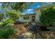Home exterior featuring a Koi pond with a bridge, lush landscaping, and mature trees at 7795 Sw 72Nd Ct, Ocala, FL 34476