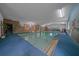 Indoor pool with carpeted deck, accent wall with mural, and ample natural light at 7795 Sw 72Nd Ct, Ocala, FL 34476