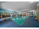 Spacious indoor pool with muraled walls, diving board, and comfortable carpet surrounds at 7795 Sw 72Nd Ct, Ocala, FL 34476