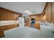 Well-lit kitchen featuring tile countertops, wooden cabinetry, modern appliances, and views to living room at 7795 Sw 72Nd Ct, Ocala, FL 34476