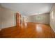 Open living room with gleaming hardwood floors, natural light from windows and an open door to another room at 7795 Sw 72Nd Ct, Ocala, FL 34476