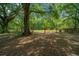Gated entrance to a private, wooded property with mature trees and lush greenery at 7795 Sw 72Nd Ct, Ocala, FL 34476