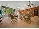 Sunroom with wood paneling and tile floor, with large windows, seating area, and a ceiling fan at 7795 Sw 72Nd Ct, Ocala, FL 34476