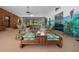 Spacious sunroom featuring tile flooring, wood paneling, and multiple seating areas with views of the outdoors at 7795 Sw 72Nd Ct, Ocala, FL 34476