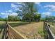 Sprawling yard surrounded by a rustic fence and mature trees under a blue sky with puffy clouds at 7795 Sw 72Nd Ct, Ocala, FL 34476