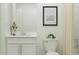 All-white bathroom with a vanity, commode, decorative greenery, and neutral-toned shower curtain at 3506 Kimbrough Dr, Lake Wales, FL 33859