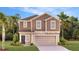 Two-story home featuring a two-car garage, neutral color palette, and well-manicured lawn at 5605 Gingham Dr, Kissimmee, FL 34758