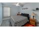 Charming bedroom with a black and white checkered bedspread, neutral walls, and bright natural light at 7040 Tamarind Dr, Lake Wales, FL 33898