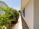 Charming home exterior featuring a well-maintained walkway and vibrant landscaping along the side of the house at 7040 Tamarind Dr, Lake Wales, FL 33898