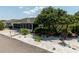 Home exterior featuring well maintained landscaping and a beautiful mature shade tree at 7040 Tamarind Dr, Lake Wales, FL 33898