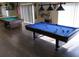 Game room with two billiard tables, ample natural light and stylish lighting fixtures at 7040 Tamarind Dr, Lake Wales, FL 33898