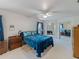 Comfortable main bedroom with carpet flooring, a ceiling fan, a large bed, and mirrored closet doors at 7040 Tamarind Dr, Lake Wales, FL 33898