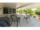 Relaxing covered patio perfect for outdoor dining with comfortable seating and a serene backyard view at 7040 Tamarind Dr, Lake Wales, FL 33898