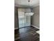A dining area has waterproof flooring, a modern chandelier, and windows with blinds at 12020 Villanova Dr # 107, Orlando, FL 32837