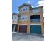 A three-story condo features private balconies and garage doors with unique colors at 12020 Villanova Dr # 107, Orlando, FL 32837