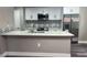 An updated kitchen features white cabinets, stainless steel appliances, and a backsplash at 12020 Villanova Dr # 107, Orlando, FL 32837