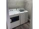 A laundry room features a washer and dryer, as well as wire shelving for storage at 12020 Villanova Dr # 107, Orlando, FL 32837