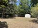 Spacious backyard featuring a storage shed and mature trees, perfect for outdoor activities at 1230 Jasmine Rd, Apopka, FL 32703