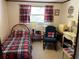 Comfortable bedroom with a cozy bed and a window with patterned red and black plaid curtains at 1230 Jasmine Rd, Apopka, FL 32703