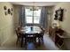 Dining room with hardwood table and chairs, decorative curtains, and plenty of natural light at 1230 Jasmine Rd, Apopka, FL 32703