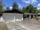 Two-car garage with white doors, driveway, and well-maintained landscaping enhance curb appeal at 1230 Jasmine Rd, Apopka, FL 32703