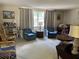 Cozy living room featuring plush armchairs, neutral carpeting, and natural light from the window at 1230 Jasmine Rd, Apopka, FL 32703