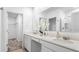 Bright bathroom featuring double sinks, quartz countertops, modern fixtures and a separate shower stall at 5657 Portico Pl, Kissimmee, FL 34758