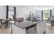 Open-concept kitchen with a large island, stainless steel dishwasher, and views into the dining and living areas at 5657 Portico Pl, Kissimmee, FL 34758