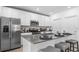 Modern kitchen features a stainless steel refrigerator, microwave, range, and island with seating at 5657 Portico Pl, Kissimmee, FL 34758